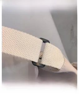 Close-up of reinforced canvas strap and durable plastic buckle on the shoulder bag