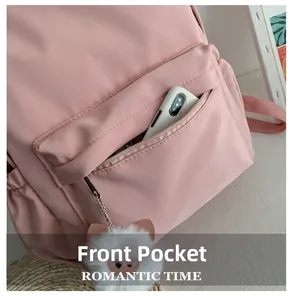 Détail de la poche avant du sac à dos rose avec porte-clé cochon et rangement téléphone