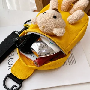 Detailed interior view of a yellow canvas bear crossbody bag showing its large storage capacity