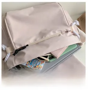 Interior view of large capacity beige messenger bag showing laptop and daily essentials