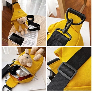 Detail view of yellow canvas chest bag with cute plush bear and adjustable strap