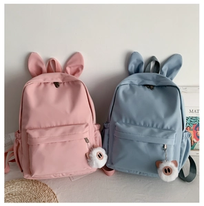 Détail d'un sac à dos mignon en nylon avec oreilles de lapin et pendentif en peluche