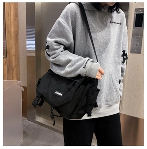 Side view of a black functional messenger bag showing the zipper and buckle details