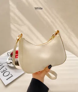 Details einer minimalistischen cremeweißen Hobo-Bag mit goldener Hardware und Lederriemen
