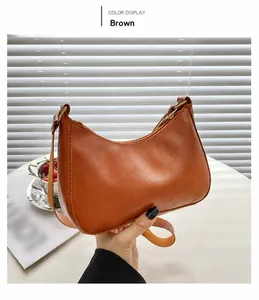 Detailansicht einer braunen halbmondförmigen Ledertasche mit Reißverschluss und Golddetails