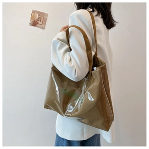 Détail du grand sac cabas brillant caramel avec logo Skiffly vert et fine bandoulière