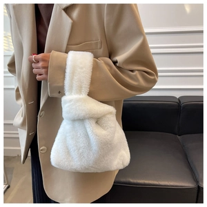 Close-up of white plush handbag featuring unique knot closure handle and soft texture