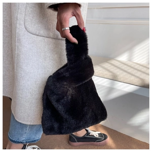Détail d'un sac à main en fausse fourrure noire douce avec poignée torsadée pour l'hiver