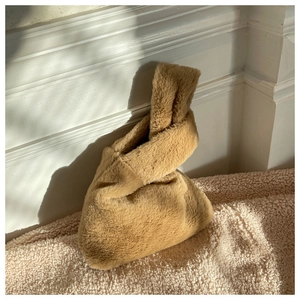 Detail of camel plush knot handbag showing soft faux fur texture and minimalist design