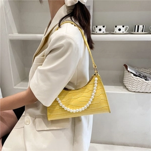 Yellow faux crocodile underarm bag with elegant large pearl chain on white background