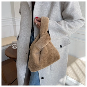 Gros plan d'un sac à main en fausse fourrure duveteuse marron avec poignée unique