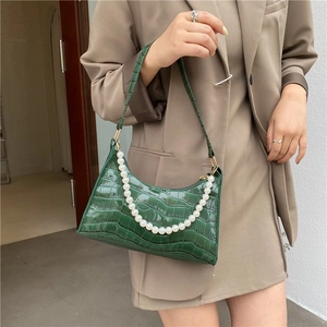 Dark green crocodile texture armpit bag with elegant pearl chain worn by a model