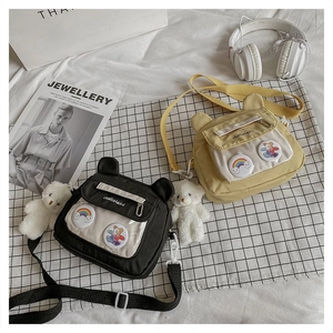 Detail of cute bear and rabbit nylon tote bags with clear pockets and badges