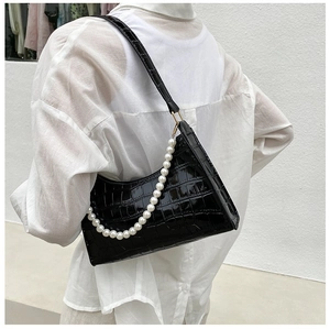 Close-up of black crocodile pattern underarm bag with decorative pearl chain and shoulder strap