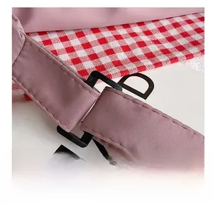 Detail of pink fabric strap with black rectangular buckle and premium stitching
