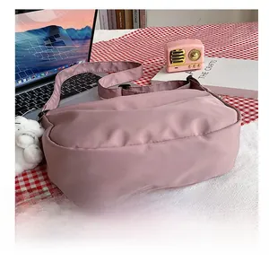 Close-up of the wear-resistant base of this pink nylon crescent-shaped crossbody bag