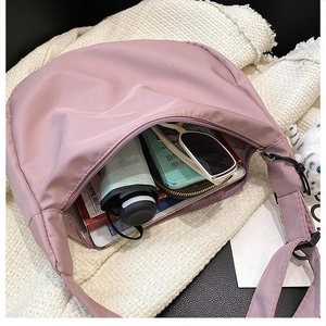 Interior view of spacious pink nylon crescent bag showing capacity for daily essentials