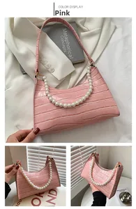 Detail of pink faux crocodile leather shoulder bag with large pearl chain and strap