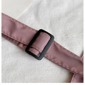 Detail of adjustable nylon shoulder strap with plastic buckle in dusty pink color