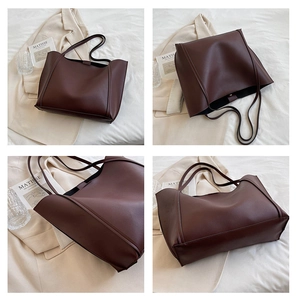 Detail view of deep brown faux leather tote bag showing soft texture and fine stitching