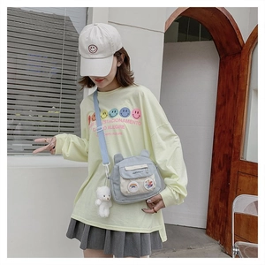 Detail of light blue nylon bag with cute bear ears and rainbow pocket on model