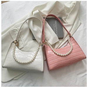 Detail of crocodile embossed faux leather shoulder bags with elegant large pearl chain strap