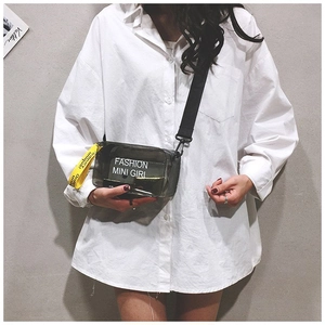 Dettaglio borsa a sella in PVC nero traslucido con slogan FASHION MINI GIRL e tracolla