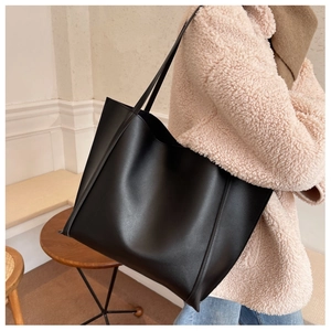 Vue latérale du grand sac cabas vintage noir sur mannequin pour un look chic au quotidien