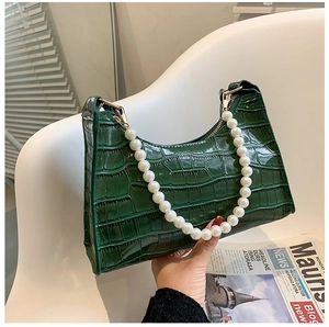 Detailed macro view of dark green faux crocodile leather and large pearl handle accent