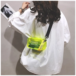 Borsa a sella in PVC giallo neon trasparente con tracolla nera indossata da una modella