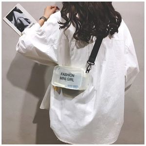 Piccola borsa a tracolla in PVC trasparente indossata da modella con camicia bianca