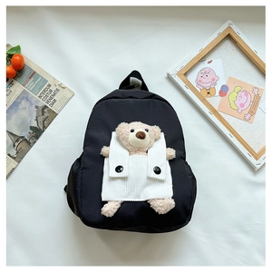 Detailed view of children's black backpack with cute plush teddy bear in white vest