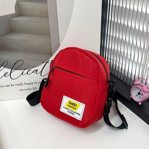 Dettaglio della borsa a tracolla in nylon rosso con tasca a zip e tracolla regolabile