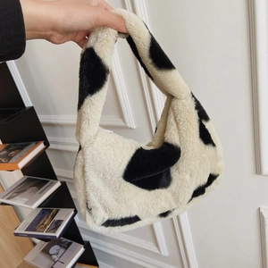 Close-up of fluffy faux fur cow print tote bag with soft texture and integrated handle
