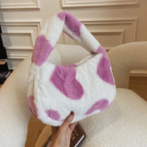 Detail of plush hobo bag with purple and white cow print texture and soft handle