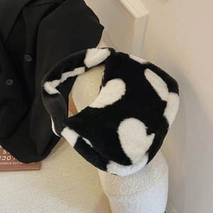 Detailed view of a soft faux fur tote bag with black and white cow print texture