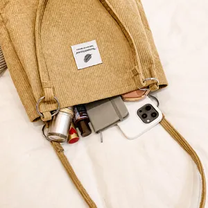 Macro shot of corduroy tote bag showing spacious interior with phone and notepad