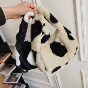 Detail shot of plush tote bag with black and white cow print and soft faux fur texture