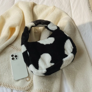 Detail of plush cow print tote bag with soft faux fur texture and integrated handle