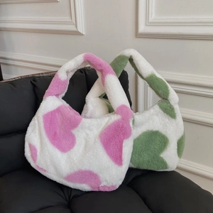 Detailed view of soft faux fur tote bags with pink and green heart patterns