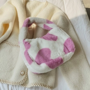Detail of soft plush tote bag featuring pink cow print pattern and single top handle