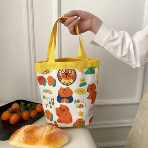 Detailed close-up of a mini canvas bucket bag featuring cute orange cartoon tiger prints