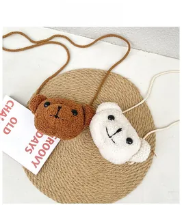 Détail de mini sacs ours en peluche marron et blanc avec bandoulière en laine d'agneau