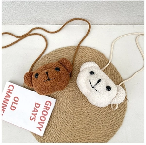 Détail de sacs bandoulière ours en peluche marron et blanc avec texture polaire