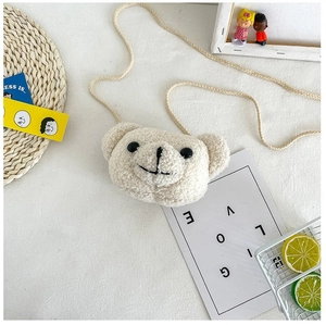 Gros plan détaillé d'un sac bandoulière en peluche ours blanc crème sur un tapis décoré