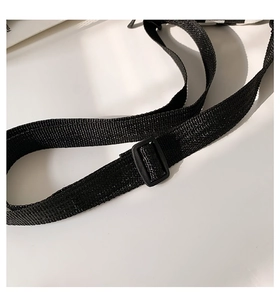 Detail eines verstellbaren schwarzen Nylongurts mit robuster Kunststoffschnalle für Taschen