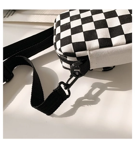 Detail der karierten Segeltuchtasche mit schwarz-weißem Muster und Trageriemen