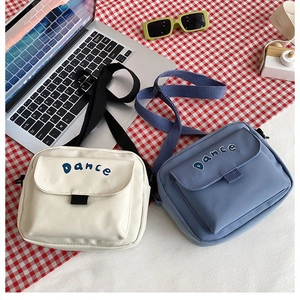 Detail of Korean style canvas crossbody bags in white and blue with Dance print