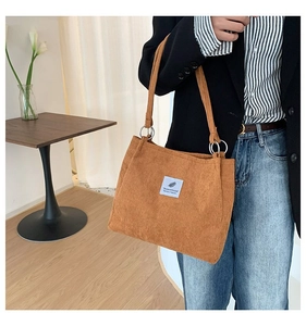 Brown corduroy tote bag showing textured fabric and light blue patch detail