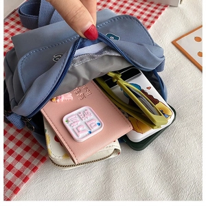 Detail shot of blue canvas crossbody bag showing large capacity for phone and wallet